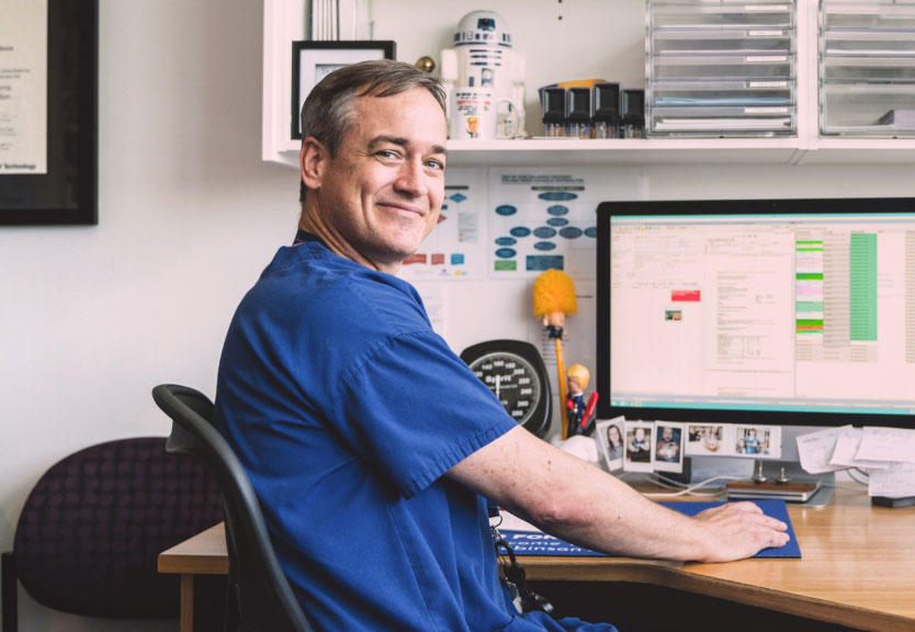 Medical specialist sitting in front of practice management software on desktop computer