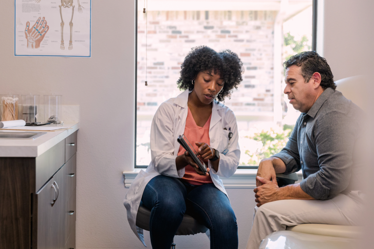 Doctor with patient explaining details with a tablet