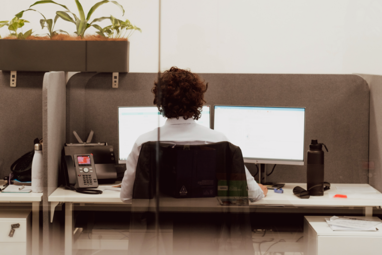 Person working at desktop computer with two screens